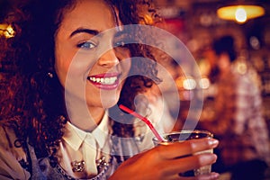 Portrait of young woman having a cocktail drink