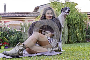 Portrait of young woman with her hunting dog in the garden