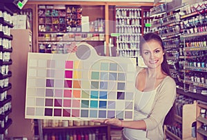 Portrait of young woman holding color sample palette