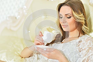 Portrait of young woman holding cup of coffee