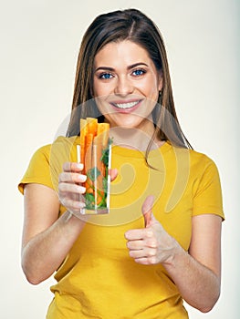 portrait of young woman holding glass with carrot.