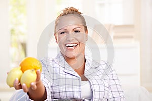 Portrait of young woman holding lemons in hand