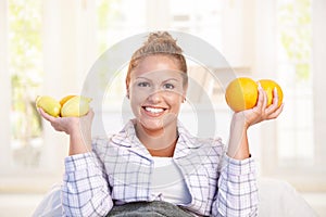 Portrait of young woman holding lemons in hands