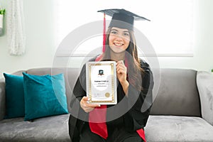 Portrait of a young woman holding proudly her college degree