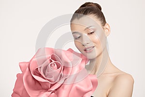 Portrait Young woman holding a rose in her hands. Pink big flower. Clean skin concept