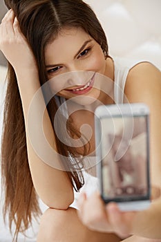 Portrait of a Young Woman Holding a Smartphone Digital Camera an