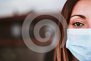 Portrait of young woman at home wearing a protective mask. Coronavirus covid-19 concept