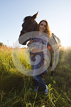 Portrait of a young woman with horse in meadow at summer day. wide angle lens