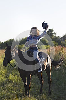 Portrait of a young woman and horse in the meadow at sunny summer