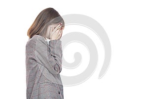 Portrait of a young woman in a jacket holding her hands near her face. Crying, tears, years. Isolated on white