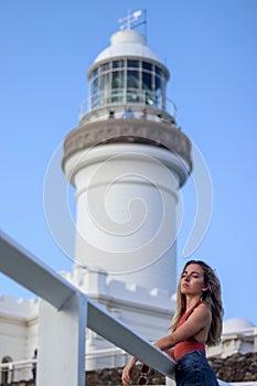 Portrait of young woman leaning next to the lighthouse of Byron Bay, Australia