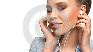 Portrait of a young woman listening to the music via earphones.