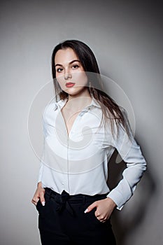 Portrait of young woman with long black hair in business wear.