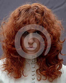 Portrait of a young woman with long curly red hair.