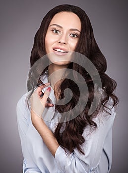 Portrait of a young woman with long luxurious hair hair. Makeup and gentle smile