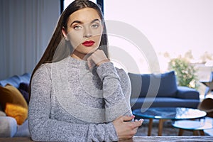 Portrait of young woman looking at camera while sitting at desk