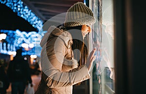 Portrait of a young woman looking at the shop window. Shopping people sale concept