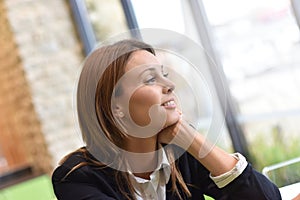 Portrait of young woman looking thorugh window photo