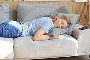 Portrait of young woman lying on couch and sleeping