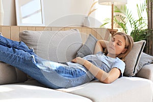 Portrait of young woman lying on couch and sleeping