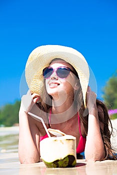 Portrait of young woman lying in straw hat in