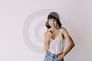 Portrait of young woman making the call me sign gesture isolated on a white background