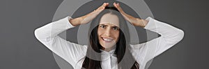 Portrait of young woman making grimaces over gray background