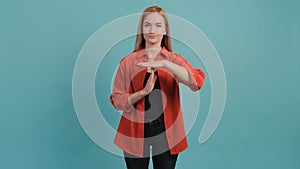 Portrait of a young woman making the time out gesture, asking for a break.