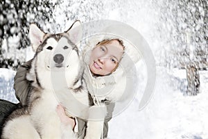 Portrait of young woman with malamute puppy