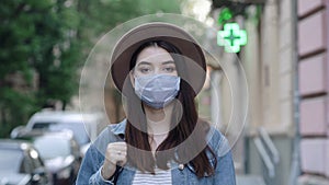 Portrait of young woman in medical mask on vacation in old europe city