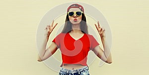 Portrait young woman model wearing a red baseball cap, t-shirt on a background