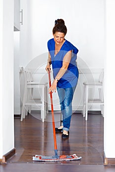 Portrait Of Young Woman Mopping Floor At Home . Cleaning Sevice