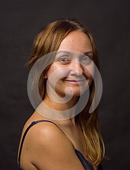 Portrait of young woman, no make up, low key, brown dark hair, no retouch making expressions