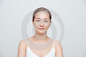 Portrait of young woman with no make up over white background