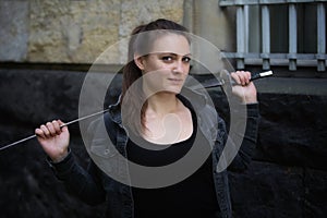 Portrait of young woman outdoors with epee