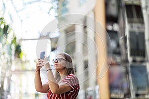 Young woman taking photo with her smart phone