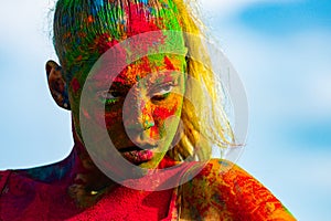 Portrait of young woman with paint make-up. Color face with colorful holi splash. Concept for Indian festival Holi.