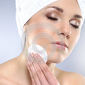 Portrait of a young woman pampering her face