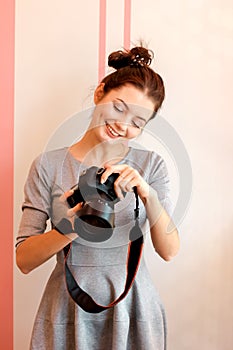 Portrait of young woman photographer smiling and holding her camera