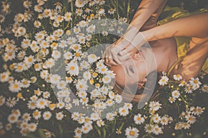 Portrait of young  woman with radiant clean skin lying down amid flowers