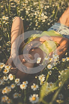 Portrait of young  woman with radiant clean skin lying down amid flowers