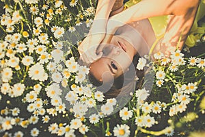 Portrait of young  woman with radiant clean skin lying down amid flowers