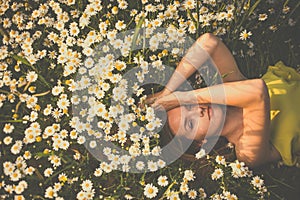 Portrait of young  woman with radiant clean skin lying down amid flowers