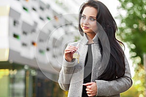 Portrait of a young woman realtor or businesswoman standing outdoors on the modern residential district background