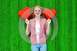 Portrait young woman with red an air balloons in the shape of a heart