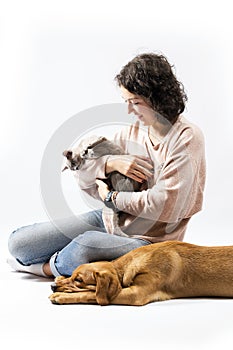 Portrait of young woman, red fox labrador retriever and burma cat on white background.