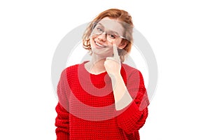 Portrait of young woman in red sweater pointing finger at glasses on face isolated on white studio background. Vision check