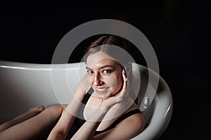 Portrait of a young woman relaxing in the bathtub, organic skin-care at the spa, wellbeing and self-care concept