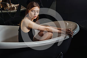 Portrait of a young woman relaxing in the bathtub, organic skin-care at the spa, wellbeing and self-care concept