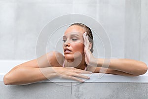 Portrait of a young woman relaxing in the bathtube